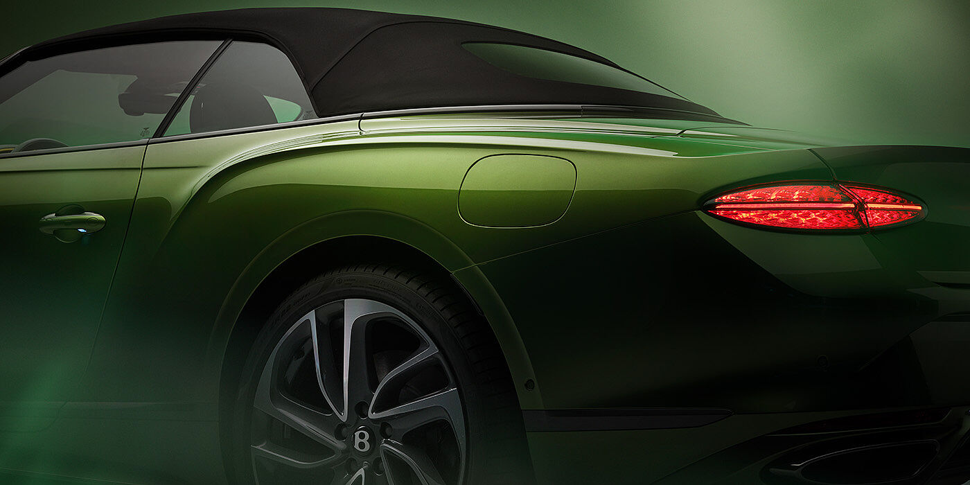 Bentley Budapest Bentley New Continental GTC Speed rear haunch and tail lamp in Tourmaline Green paint and dark tint brightware with black hood up and illuminated head lamps